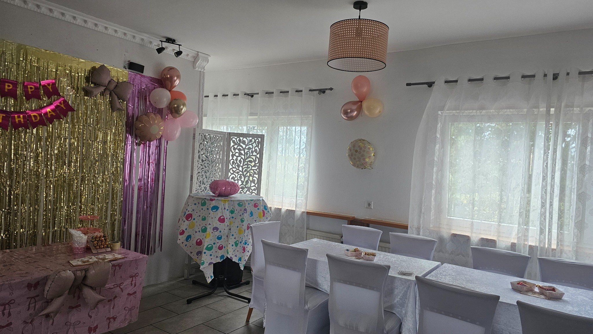 Festlich dekorierter Raum mit rosa und goldenen Akzenten