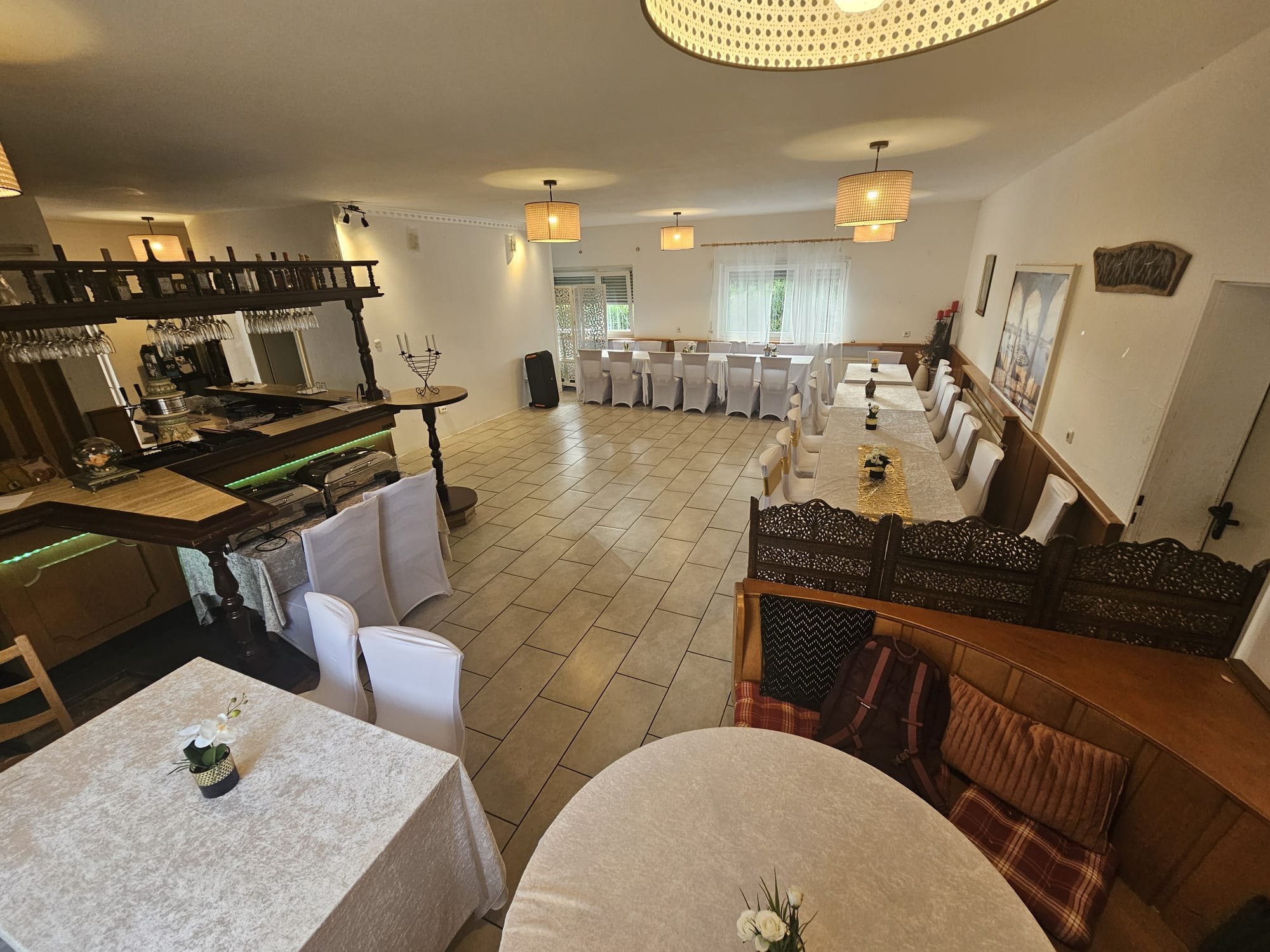 Blick über den großzügigen Veranstaltungsraum mit Tischen und Sitzplätzen